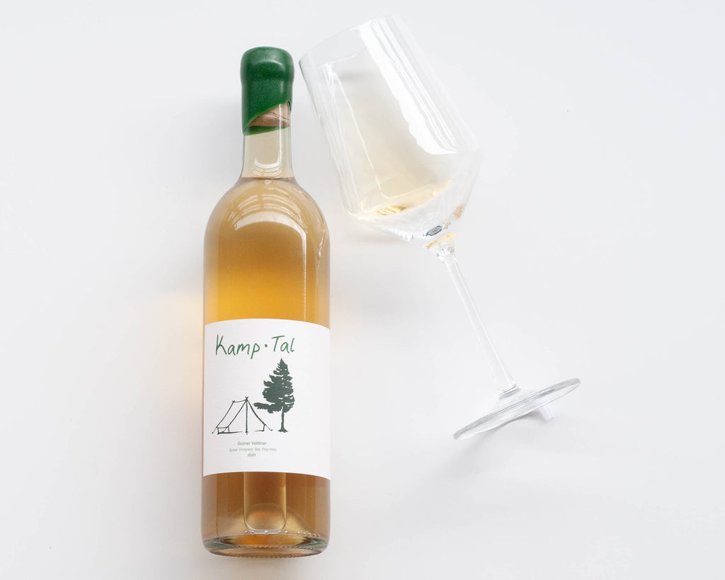 Flat lay with a bottle of Kamp Tal Gruner Veltliner and a glass of white wine
